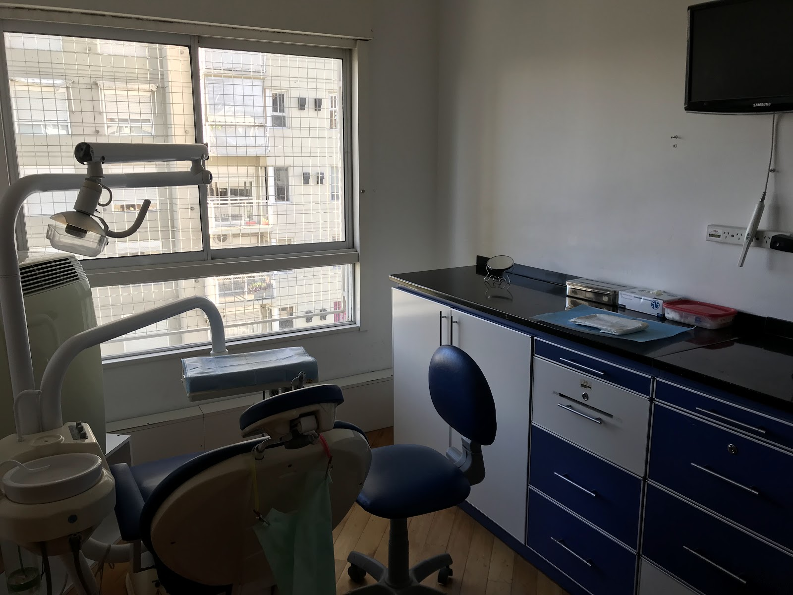Recepción y sala de espera boutique de Central Dent Buenos Aires con diseño biofílico y mostrador curvado en madera natural